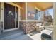 Inviting front porch with stone accents, seating, and decorative Colorado flag, enhancing curb appeal at 5425 E 125Th Pl, Thornton, CO 80241