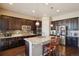 Modern kitchen with granite countertops, stainless steel appliances, dark cabinetry and a central island at 5425 E 125Th Pl, Thornton, CO 80241
