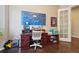 A home office with a large desk, built in cabinets, and a white-framed blue map hanging on the wall at 5425 E 125Th Pl, Thornton, CO 80241