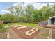 Expansive backyard featuring a well-maintained lawn, a fire pit, garden boxes, and a deck with outdoor seating at 5445 Nebraska Way, Denver, CO 80246