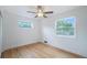 Bright bedroom featuring refinished hardwood floors, white walls, and large windows offering outdoor views at 5445 Nebraska Way, Denver, CO 80246