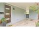 Inviting carport entrance with modern front door and outdoor decor, enhanced by lovely flowering plants at 5445 Nebraska Way, Denver, CO 80246