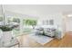 Bright living room with a comfortable gray sofa, large windows, and hardwood floors for a modern feel at 5445 Nebraska Way, Denver, CO 80246