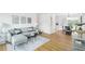 Bright living room open to the dining area, featuring hardwood floors and a comfortable gray sectional sofa at 5445 Nebraska Way, Denver, CO 80246