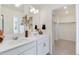 Bright bathroom featuring a double vanity, contemporary fixtures, and a walk-in closet for optimal convenience at 9855 Biscay St, Commerce City, CO 80022