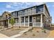 Beautiful townhome with blue siding, stone accents, and a charming front porch with white railings at 9855 Biscay St, Commerce City, CO 80022