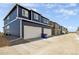 New townhome featuring a two-car garage and modern architecture, providing comfortable and convenient living at 9855 Biscay St, Commerce City, CO 80022