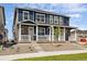 Well-appointed townhome featuring blue siding, stone accents, and a cozy front porch at 9855 Biscay St, Commerce City, CO 80022