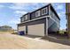 Modern two-story house with two-car garage and blue siding under a bright sky at 9855 Biscay St, Commerce City, CO 80022