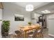 Virtually staged dining area with wooden table and kitchen view at 14191 E Jewell Ave # 203, Aurora, CO 80012
