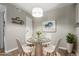 Virtually staged dining area with glass table and white chairs at 14191 E Jewell Ave # 203, Aurora, CO 80012
