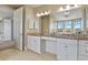 Bathroom with white cabinetry, double vanity, large mirror, and great natural light at 2960 High Prairie Way, Broomfield, CO 80023