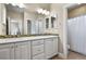 Bathroom with double sinks, white cabinets, and mosaic backsplash at 2960 High Prairie Way, Broomfield, CO 80023