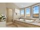 Bright bathroom featuring a soaking tub, tiled shower, and multiple windows at 2960 High Prairie Way, Broomfield, CO 80023