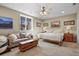 Bedroom with a cozy sofa, a bed with fluffy bedding, and mountain artwork at 2960 High Prairie Way, Broomfield, CO 80023
