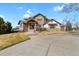 Stunning stone home featuring a grand entryway with a well manicured lawn at 2960 High Prairie Way, Broomfield, CO 80023