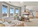 Sitting area in the main bedroom featuring large windows, comfortable seating, and a cozy fireplace at 2960 High Prairie Way, Broomfield, CO 80023