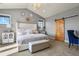 Bright main bedroom features neutral walls, carpet, sliding barn door, and an upholstered bed with tufted headboard at 2960 High Prairie Way, Broomfield, CO 80023