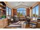 Wood-paneled office with built-in bookshelves, a large window, and comfortable seating at 2960 High Prairie Way, Broomfield, CO 80023