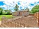 View of the backyard with fenced garden plot, spacious lawn, and convenient access at 458 Cherry St, Hudson, CO 80642