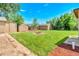 Private backyard with fire pit, storage sheds, and a well-maintained lawn perfect for outdoor living at 458 Cherry St, Hudson, CO 80642
