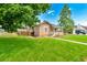 Well-maintained home with a lush green lawn, mature trees, and a welcoming front porch at 458 Cherry St, Hudson, CO 80642