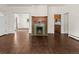 Open-concept living room with a decorative fireplace, hardwood floors, and convenient access to other rooms at 458 Cherry St, Hudson, CO 80642