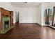 Charming living room features hardwood floors, large windows, and a beautiful fireplace with green tile at 458 Cherry St, Hudson, CO 80642