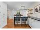 Modern kitchen features white cabinets, black countertops, open shelving, island with blue seating at 6625 E 6Th Avenue Pkwy, Denver, CO 80220