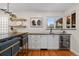 Modern kitchen featuring white cabinets, black countertops, open shelving and built in wine storage at 6625 E 6Th Avenue Pkwy, Denver, CO 80220