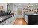 Modern kitchen featuring sleek black countertops, white cabinetry, and stylish gold hardware and lighting at 6625 E 6Th Avenue Pkwy, Denver, CO 80220