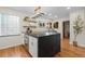 Bright kitchen with a large island featuring black countertops, white cabinets, and elegant globe lighting at 6625 E 6Th Avenue Pkwy, Denver, CO 80220