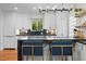 Bright kitchen with white cabinets, black countertops, open shelving and island with seating at 6625 E 6Th Avenue Pkwy, Denver, CO 80220