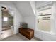 Cozy attic space with window, wooden chest, and doorway to a modern bathroom at 3632 N Marion St, Denver, CO 80205
