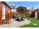 Cozy backyard featuring a stone patio with dining set, fenced yard, and outdoor grill at 3632 N Marion St, Denver, CO 80205