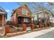 Charming red two-story home with a quaint front yard and wrought iron fence, side view at 3632 N Marion St, Denver, CO 80205