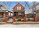 Charming red two-story home with a quaint front yard and wrought iron fence and small covered porch at 3632 N Marion St, Denver, CO 80205