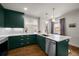 Beautiful kitchen featuring dark green cabinets, gold hardware, stainless appliances, and white countertops at 3632 N Marion St, Denver, CO 80205