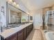 Bathroom features dual sinks, large mirror, tile flooring, soaking tub and glass shower at 16658 Prospect Ln, Broomfield, CO 80023