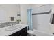 Clean bathroom featuring white tile, a mosaic accent stripe, and a vanity with a vessel sink at 4391 Mcmurdo Ct, Castle Rock, CO 80108