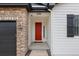Close-up of a vibrant red front door framed by stone and light siding, offering curb appeal at 4391 Mcmurdo Ct, Castle Rock, CO 80108
