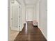 Bright hallway with wood floors, white walls, and a front door visible at the end at 4391 Mcmurdo Ct, Castle Rock, CO 80108