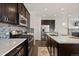 Modern kitchen with dark cabinetry, stainless steel appliances, and a white countertop island at 4391 Mcmurdo Ct, Castle Rock, CO 80108