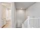 Upstairs hallway leading to a bathroom with bright lighting and white staircase at 12663 Buffington Trl, Parker, CO 80134