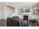 Inviting living room with a fireplace, built-in shelving, and staircase at 12663 Buffington Trl, Parker, CO 80134