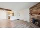 Open-concept living space with modern flooring, stone fireplace, and adjacent kitchen area with updated appliances at 10150 E Virginia Ave # 7-204, Denver, CO 80247
