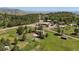 Aerial view of a charming home with a circular driveway surrounded by mature trees, mountains, and green pastures at 713 Aspen Rd, Golden, CO 80401