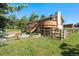 Exterior view of a house, with a second-story deck, stone-trim planter box and wood fence framing the yard at 713 Aspen Rd, Golden, CO 80401
