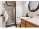 Bathroom featuring a walk-in shower, wood vanity, and an oval mirror at 713 Aspen Rd, Golden, CO 80401