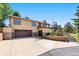 Two-story house with two-car garage, stone trim, balcony with stairs, and tasteful landscaping along a wide driveway at 713 Aspen Rd, Golden, CO 80401